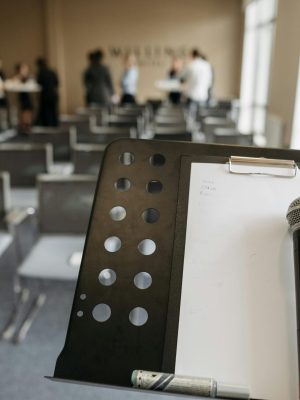 Close-up of a microphone on a stand in a conference room setting.